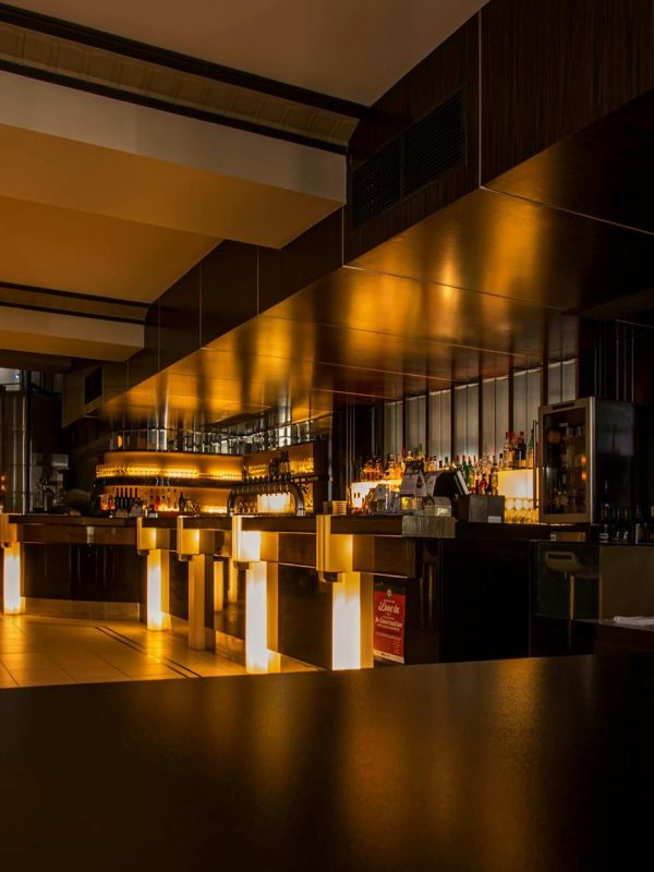Stylish modern restaurant interior with warm lighting, elegant design, and luxurious ambiance at night.